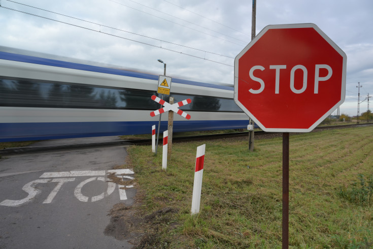 bezpieczny przejazd, przejazd kolejowo-drogowy, żółta naklejka, krzyż św. Andrzeja, znak STOP