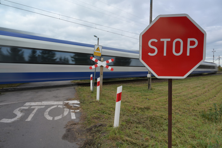 bezpieczny przejazd, przejazd kolejowo-drogowy, żółta naklejka, krzyż św. Andrzeja, znak STOP