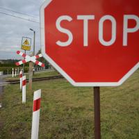 bezpieczny przejazd, przejazd kolejowo-drogowy, żółta naklejka, krzyż św. Andrzeja, znak STOP